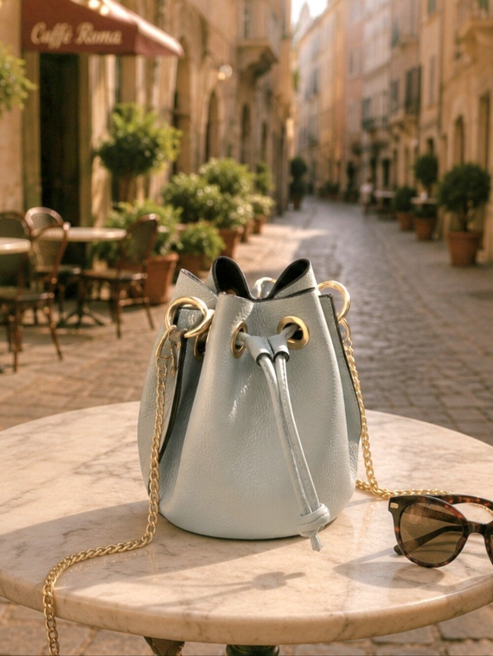 Bucket Drawstring Crossbody Bag in Light Blue with Gold Chain. 